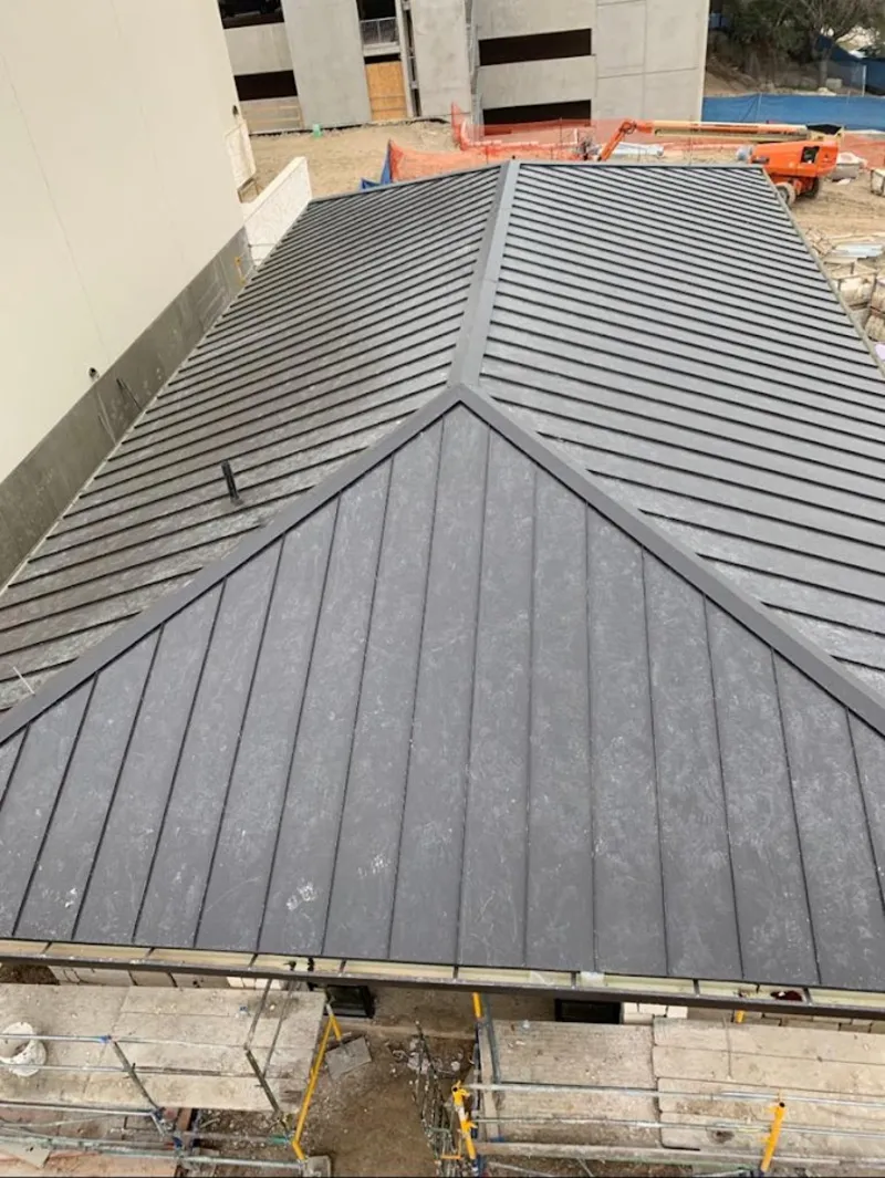 Commercial metal roof construction with crane equipment in Greenville